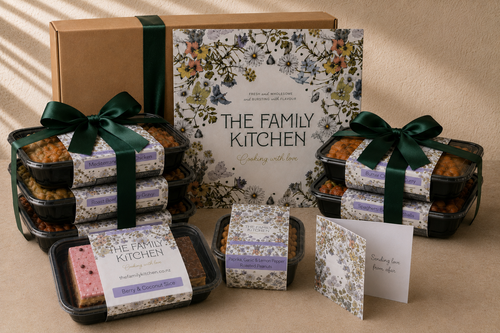 The Family Kitchen Care from Afar package with five chef-made meals, a Berry and Coconut Slice, seasoned roasted peanuts and a handwritten card.