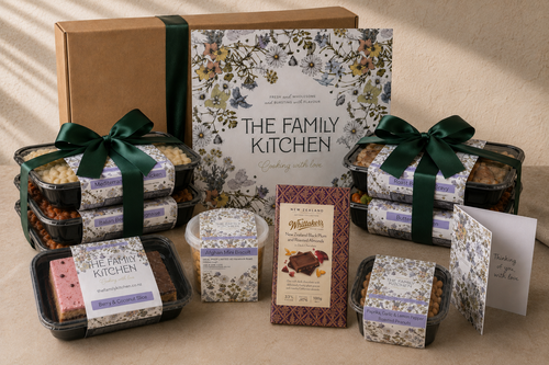 The Family Kitchen Comfort Essentials care package with four chef-made meals, two desserts, Whittaker's chocolate, roasted peanuts and a handwritten card.