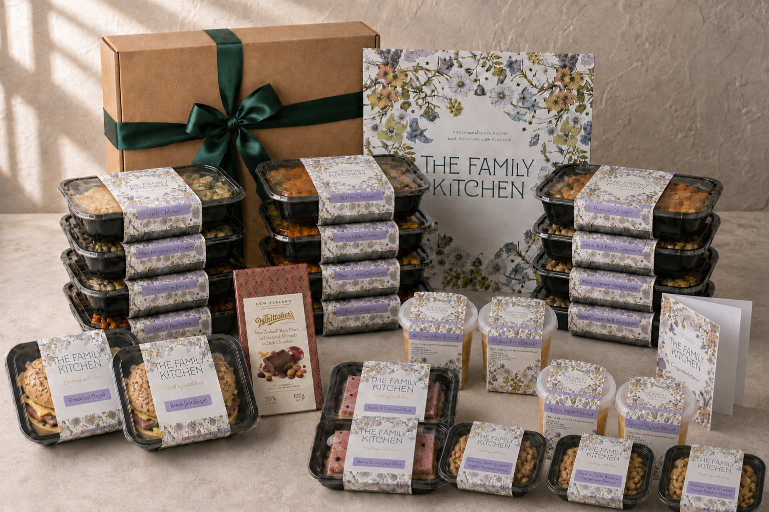 The Family Kitchen New Parent Survival Box with twelve meals, six desserts, three roasted-peanut snack packs, two Breakfast Bagels, Whittaker's chocolate and a premium card.